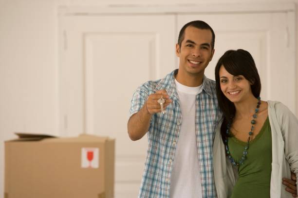 Smiling couple receiving keys to their new home